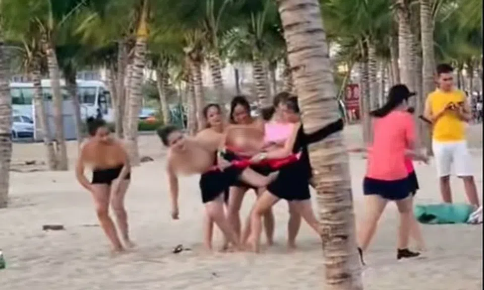 Nhóm phụ nữ để ngực trần chơi team building ở bãi biển Hạ Long